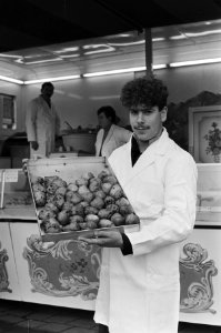 Oliebollenverkoop in Amsterdam van start verkoper met bak oliebollen, Bestanddeelnr 933-1883