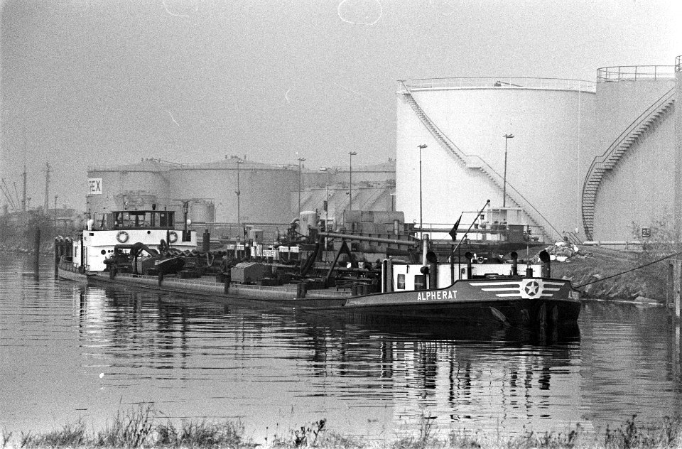 Olietanks in de Amsterdamse haven op de voorgrond een binnenvaartschip, Bestanddeelnr 926-7985