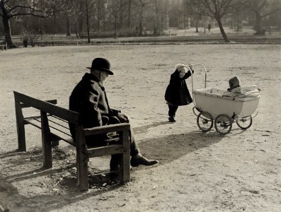 Op een bank in de zon kijkt een bejaarde naar de jeugd. Aangekocht in 1977 van fotograaf C. de Boer. Categorie 02-234 Identificatienummer 54-004271, NL-HlmNHA 54004271