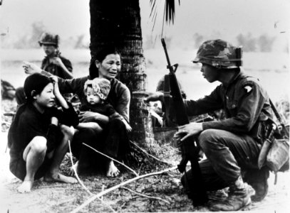 Oorlog Vietnam. Soldaat bij armzalige vrouw met kinderen, Bestanddeelnr 923-0495