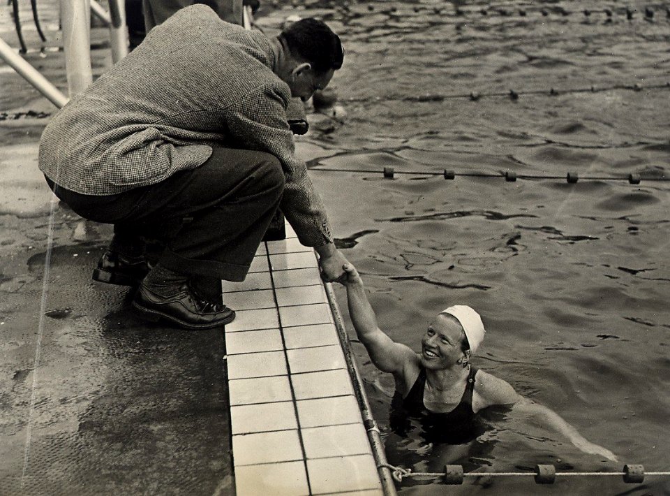 Op de 400 meter vrije slag dames won Irma Schuhmacher, waarna zij door onze Nationale doelverdediger Piet Kraak (voetbal) werd gelukgewenst. Aangekocht in 1977 van fotograaf C. de Boer. Ident, NL-HlmNHA 54010692