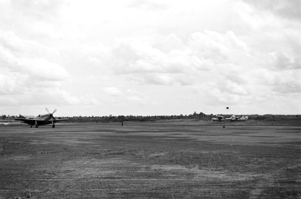 Op een vliegveld start een P51 Curtiss Mustang. Rechts zijn Catalina vliegboten , Bestanddeelnr 5602