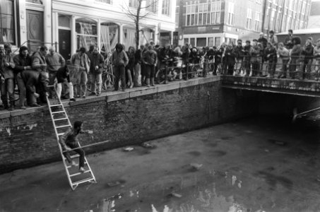 Op de Oudezijds Achterburgwal in Amsterdam wordt 50 gulden van het ijs gevist, Bestanddeelnr 933-5885 photo