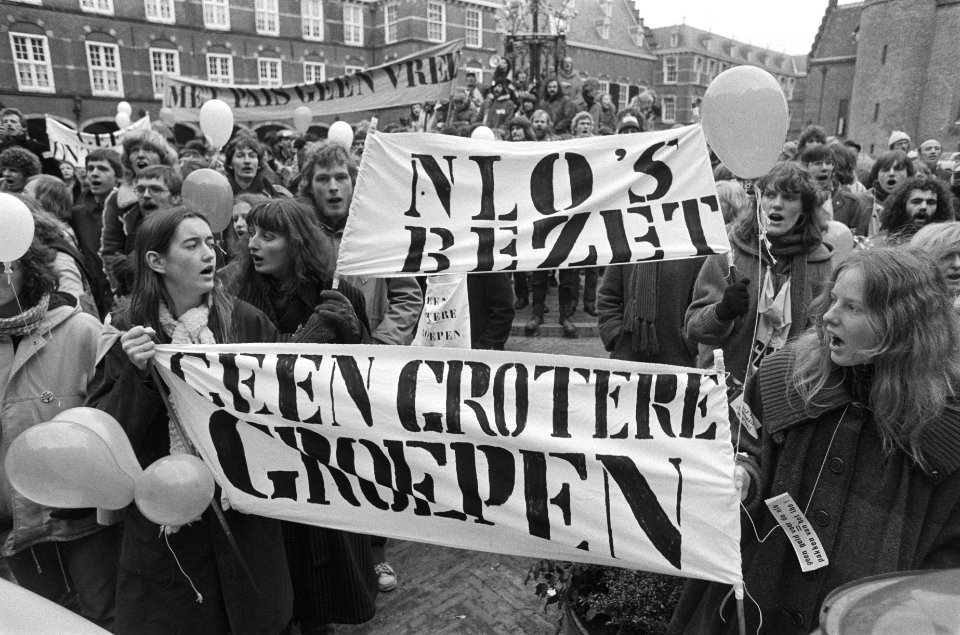 Op de spandoeken staat o.a. NLOs bezet en Geen grotere groepen, Bestanddeelnr 930-1429