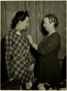 Op de jaarvergadering van de Nederlandse Vereniging van Huisvrouwen werd mevrouw Cremers geïnstallerd tot Erevoorzitster . Mevrouw Westra spelde mevrouw Cremers het insigne op. NL-HlmNHA 5400465123
