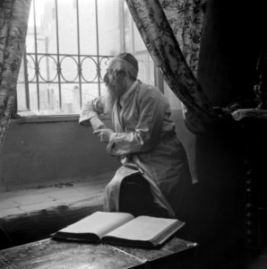 Oost-Europese rabbijn en schriftgeleerde in de wijk Mea Shearim, zittend bij een, Bestanddeelnr 255-0414