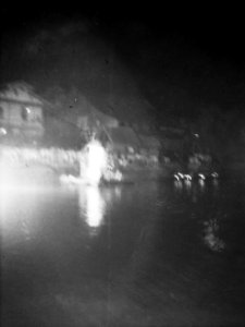 Onscherpe foto. Vreugdevuur op water, mensen op een kade kijken ernaar, Bestanddeelnr 12978