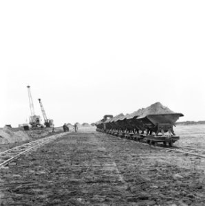Ontginning, grondbewerking, egaliseren, bezanden, geladen kipkarrentrein, arbeid, Bestanddeelnr 159-0555