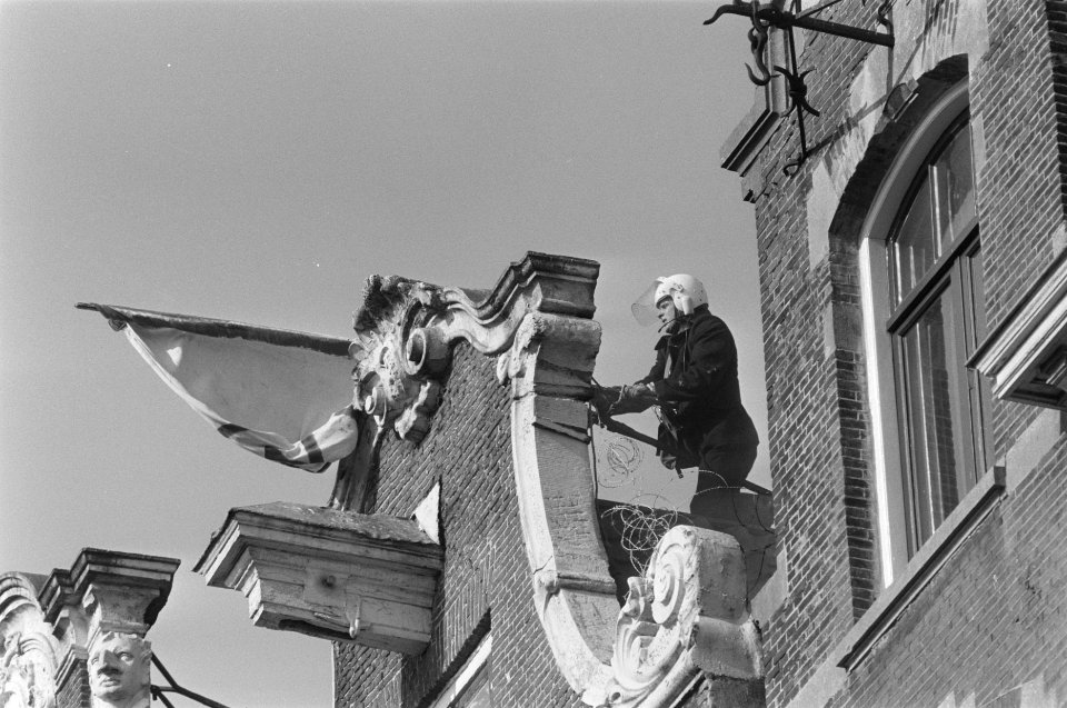 Ontruiming kraakpand Singel 114 in Amsterdam ME-er haalt krakersvlag van dak, Bestanddeelnr 933-9456