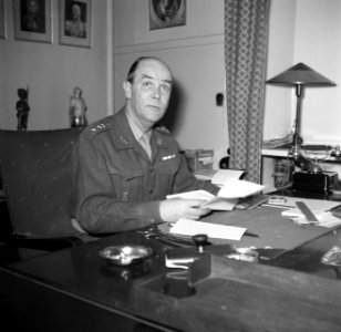Officier, vermoedelijk de bevelhebber, achter zijn bureau in zijn kantoor in de , Bestanddeelnr 252-8705