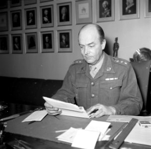 Officier, vermoedelijk de bevelhebber, achter zijn bureau in zijn kantoor in de , Bestanddeelnr 252-8706