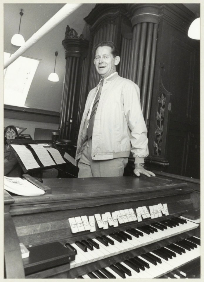 Organist Niek van der Aar bij het kerkorgel van de Sint-Jacobus de Meerderekerk aan de Liedeweg in Haarlemmerliede. NL-HlmNHA 54013078