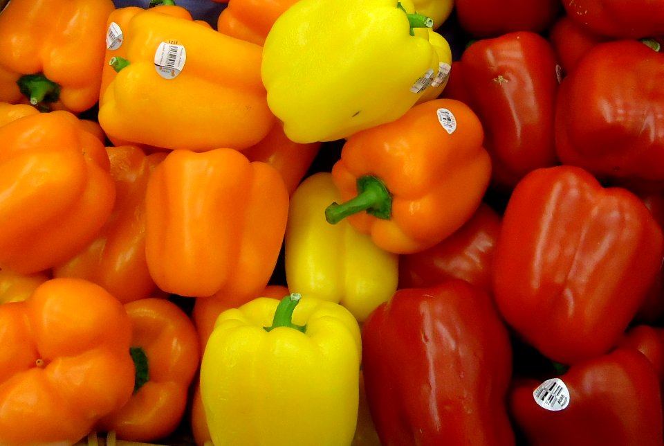 Orange and yellow and red peppers for sale in supermarket
