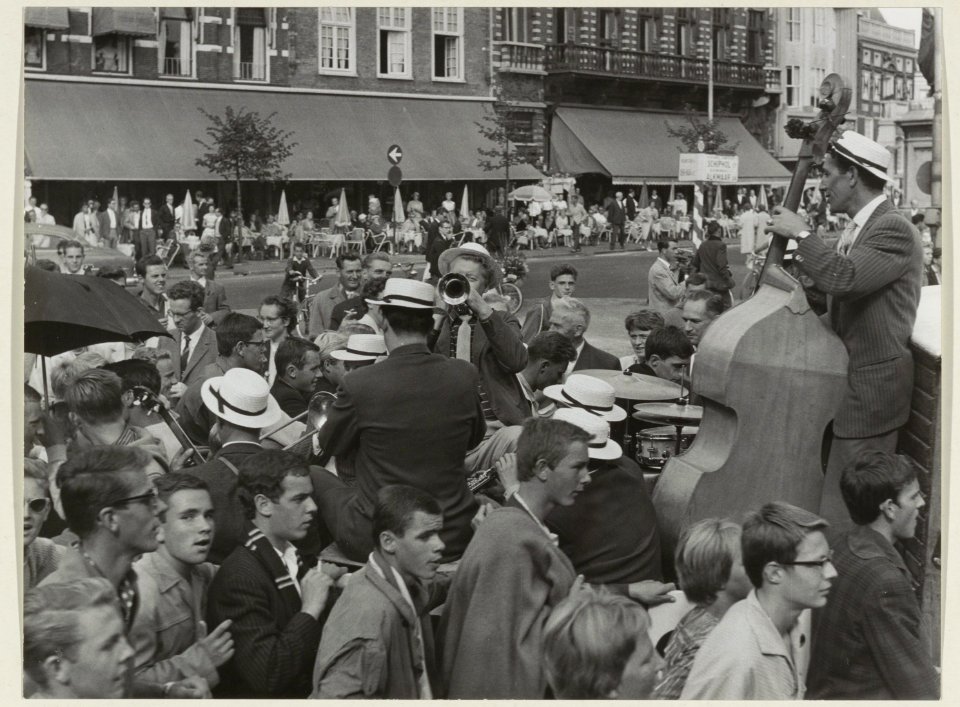Optreden van een jazzband op de Grote Markt. Op de achtergrond het terras van restaurant Brinkman. NL-HlmNHA 54004467