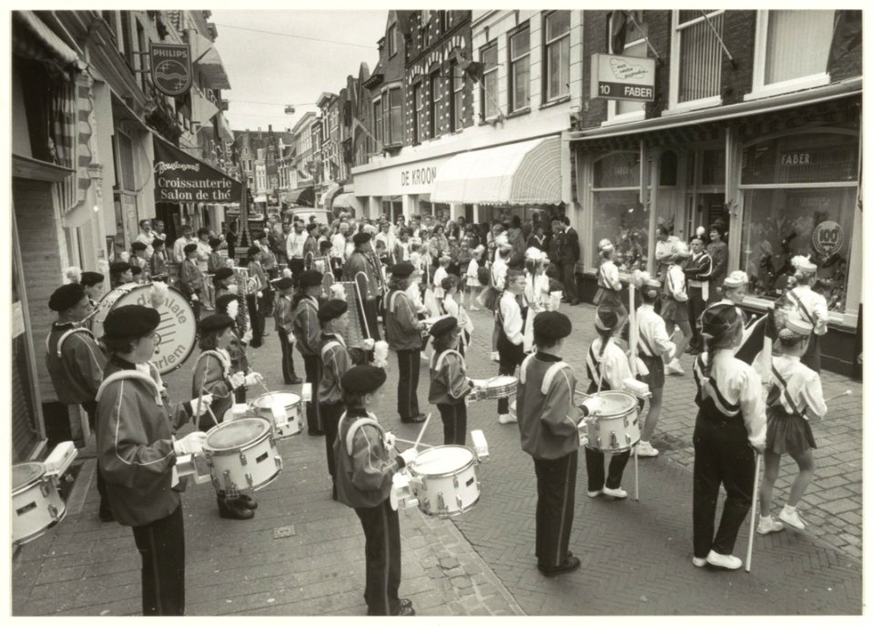 Optreden van de drumband Jong Damiate ter gelegenheid van het 100-jarig bestaan van schoenhandel Faber in de Kleine Houtstraat. NL-HlmNHA 54031423