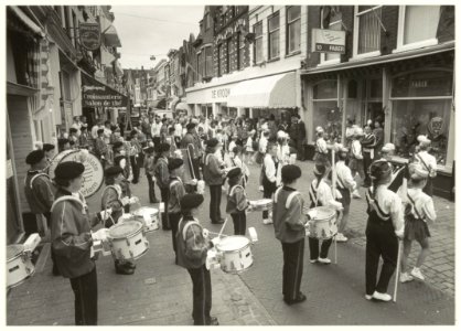 Optreden van de drumband Jong Damiate ter gelegenheid van het 100-jarig bestaan van schoenhandel Faber in de Kleine Houtstraat. NL-HlmNHA 54031423