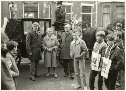 Optocht met koets waarin de oudste oud-leerling van de Maria MAVO, de 75-jarige mevr. Van der Veen werd vervoerd van het voormalige schoolgebouw aan de Koningstraat naar het nieuwe alhier , NL-HlmNHA 54025952