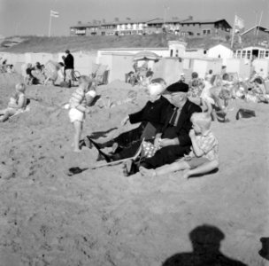 Oud echtpaar in klederdracht met twee jongetjes op het strand, Bestanddeelnr 254-4405