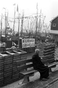 Oude visser op een bankje voor een spandoek met de tekst Open water - Ook voor, Bestanddeelnr 930-4296