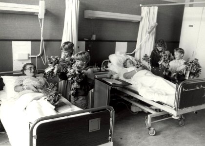 Oude traditie weer in ere hersteld kinderen van de Fuhropschool brengen bloemen van de schooltuin, aan patiënten in de St. Johannes de Deo. NB. links Mw. van Leuven, rechts Mw. van Boxtel. A, NL-HlmNHA 1478 25900 K 38