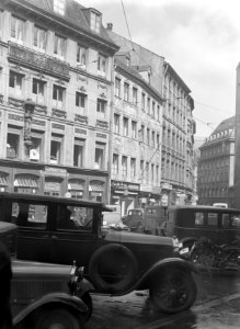 Oude gevels in het centrum met op de voorgrond geparkeerde auto's en een motorfi, Bestanddeelnr 191-0006