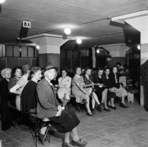Oude en jonge vrouwen wachten op bankjes in een hal, Bestanddeelnr 900-4496