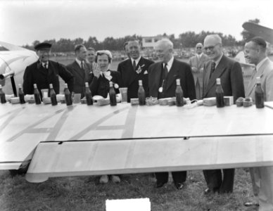 Op viegtuigvleugel zijn souvenirs uitgestald. Mannen en vrouwen in klederdracht, Bestanddeelnr 904-0954