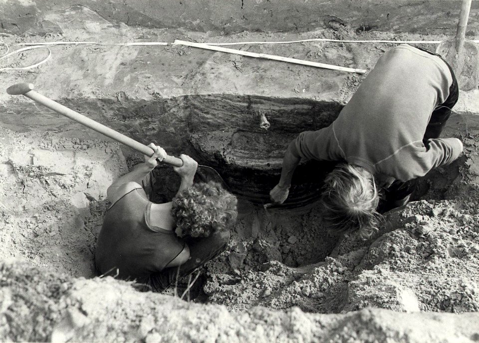 Opgraving op het terrein van het voormalige kasteel Aelbertsberg, voorzichtig wordt met een schop en een krabbertje een houten waterput uit de elfde of twaalfde eeuw uit het zand gegraven, e, NL-HlmNHA 54016585
