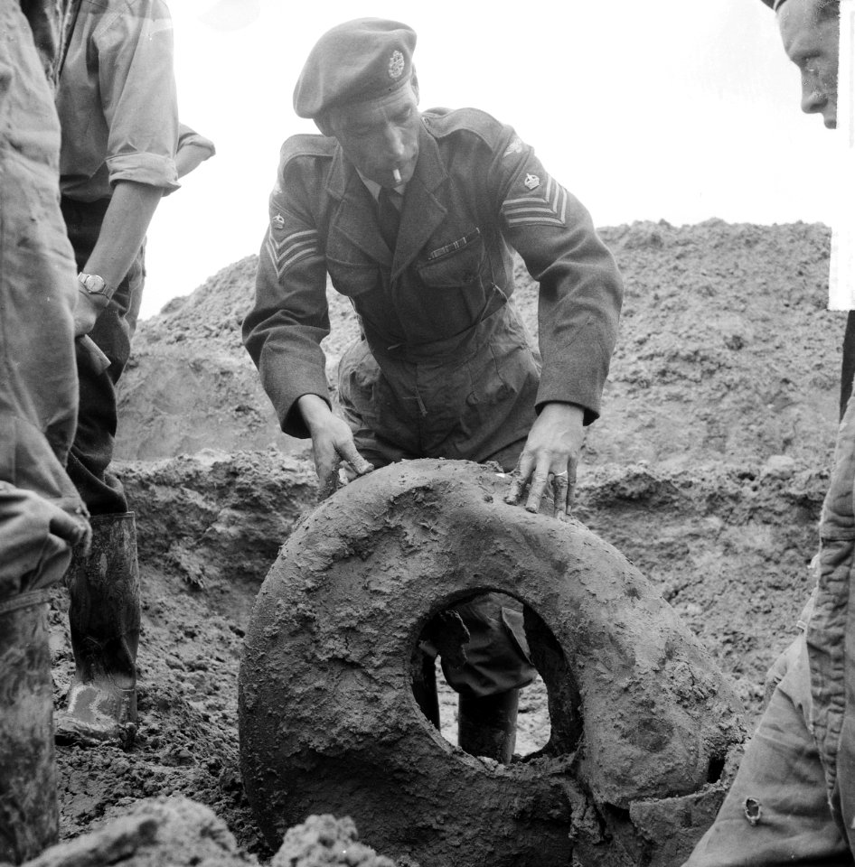 Opgraving neergeschoten vliegtuig in polder bij Waalwijk. RAF-vlieger met band v, Bestanddeelnr 912-6989