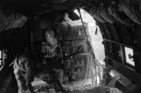 Parachutisten bezig met het droppen van voorraden vanuit de deuropening van een, Bestanddeelnr 2714