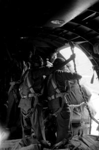Parachutisten bezig met het droppen van voorraden vanuit de deuropening van een, Bestanddeelnr 2709