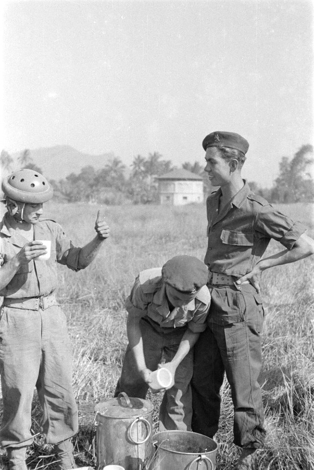 Parachutist drinkt melk uit een mok en praat met een andere militair, Bestanddeelnr 247-4-5