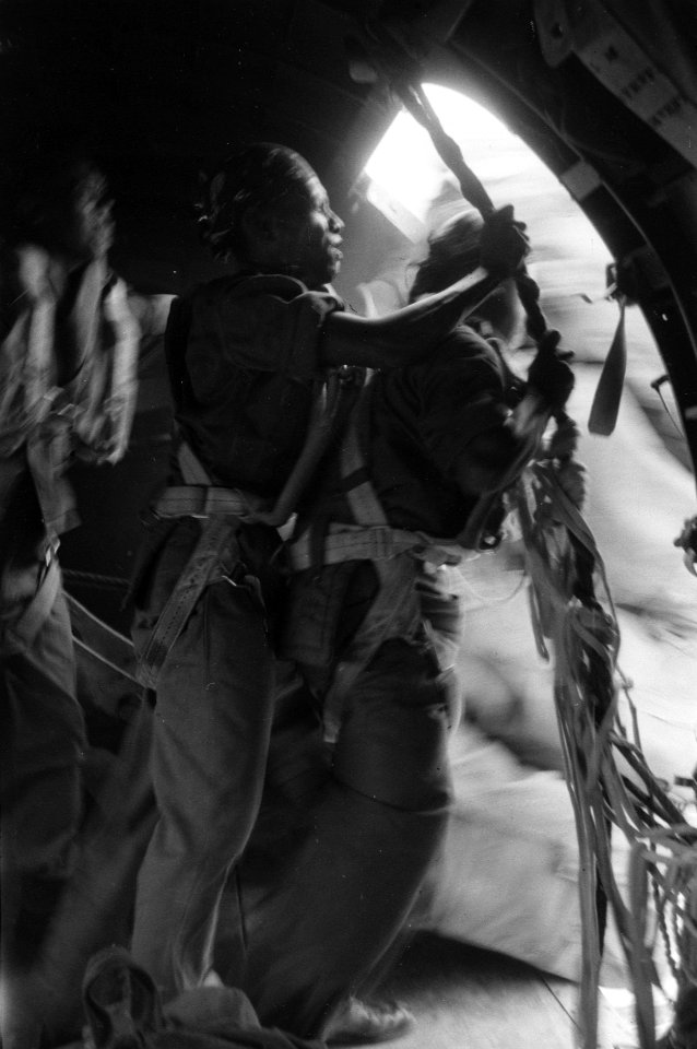 Parachutisten bezig met het droppen van voorraden vanuit de deuropening van een, Bestanddeelnr 2712