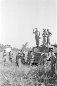 Parachutist brengt rapport uit aan man met microfoon op de cabine van de legertr, Bestanddeelnr 247-4-3