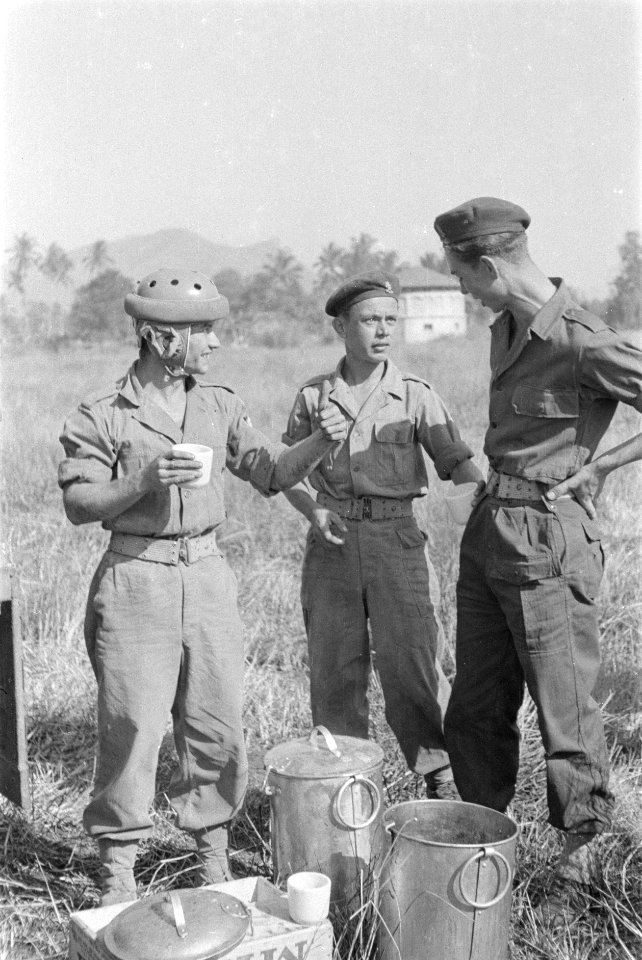 Parachutist drinkt melk uit een mok en praat met een andere militair, Bestanddeelnr 247-4-6
