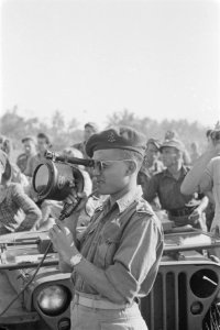 Parachutist (onderluitenant KNIL) kijkt door een speciale kijker, Bestanddeelnr 247-1-1