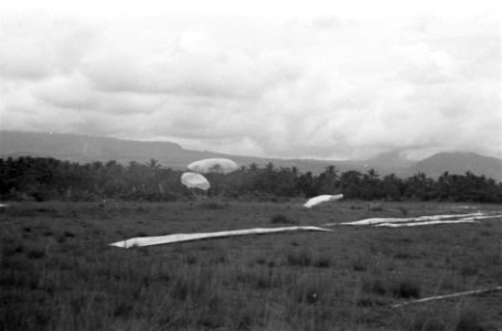 Parachutes komen neer op open veld. Droppingdoel aangegeven met stroken doek, Bestanddeelnr 5813