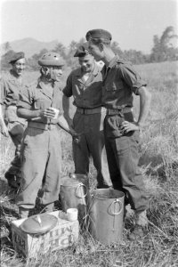Parachutist drinkt melk uit een mok en praat met een andere militair, Bestanddeelnr 247-5-2