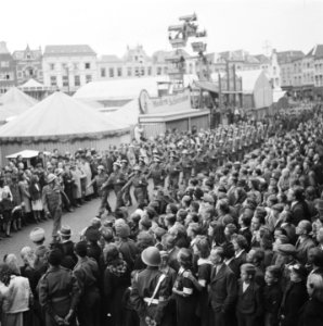 Parade van afzwaaiende troepen langs kermisterrein in Den Bosch, Bestanddeelnr 900-7800