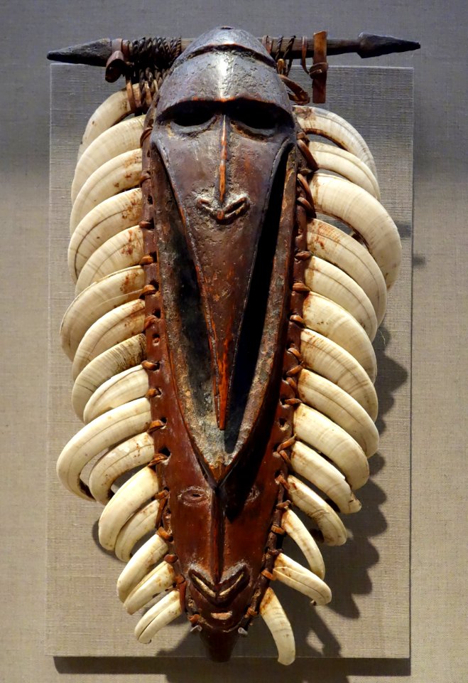 Pectoral ornament, Lower Ramu River, 19th-20th century, wood, boars' tusks, fiber, lime, with bush string bag - De Young Museum - DSC01145