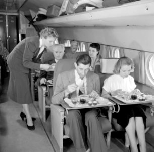 Passagiers aan de maaltijd in een KLM-vliegtuig, Bestanddeelnr 254-5476