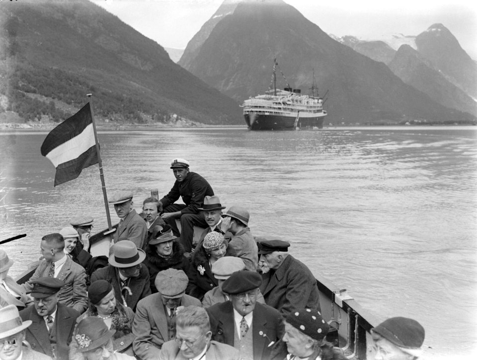 Passagiers varen in een sloep in de Fjaerlandfjord. Op de achtergrond het schip, Bestanddeelnr 189-0610