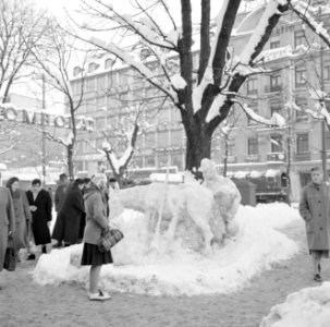 Passanten bij een beeld van een man met een ezel gemaakt van sneeuw op de Karls…, Bestanddeelnr 254-3741