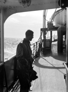 Passagier aan dek van een schip in volle zee, leunend tegen de verschansing, Bestanddeelnr 190-0413