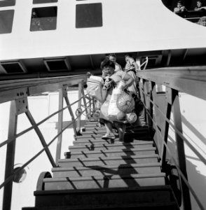 Passagiers met bagage lopen over een mobiele trap van het schip SS Zion naar d…, Bestanddeelnr 255-2169