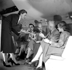 Passagiers in een vliegtuig krijgen een drankje aangeboden, Bestanddeelnr 252-2056