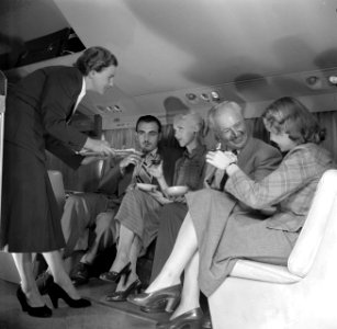 Passagiers in een vliegtuig krijgen een drankje aangeboden, Bestanddeelnr 252-2057