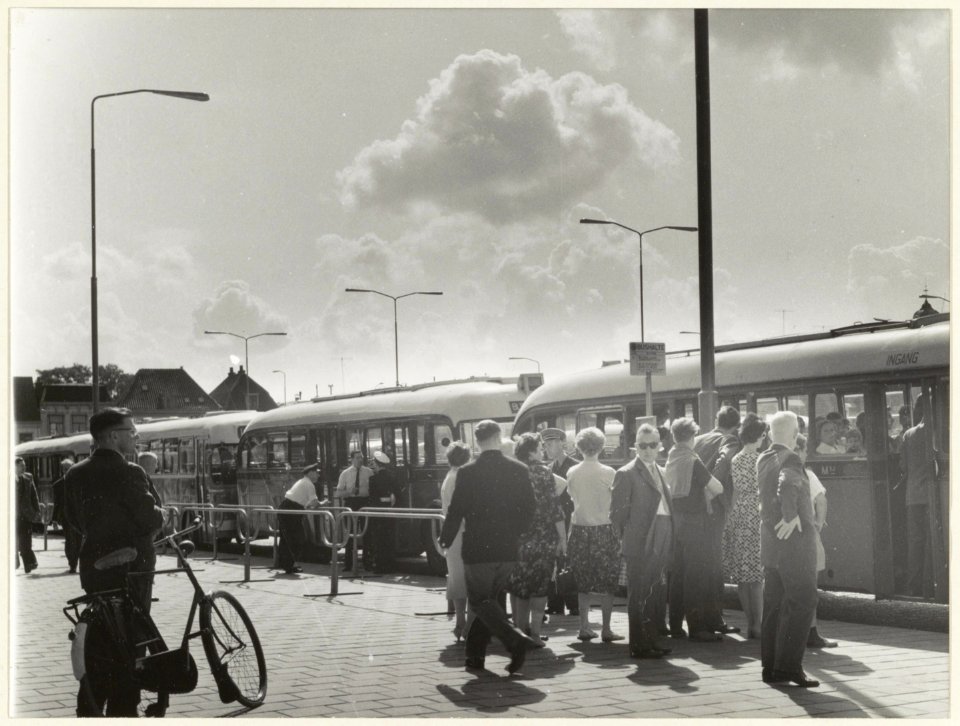 Passagiers en bussen bij de extra bushalte op het Stationsplein voor de bestemming Bloemendaalse Strand. NL-HlmNHA 54004476