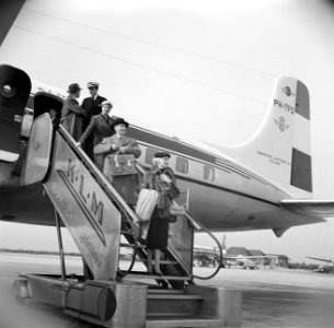 Passagiers gaan via de trap van boord van een KLM passagiersvliegtuig onder toez, Bestanddeelnr 252-1252