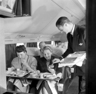 Passagiers aan de maaltijd in een KLM-vliegtuig, Bestanddeelnr 254-5474